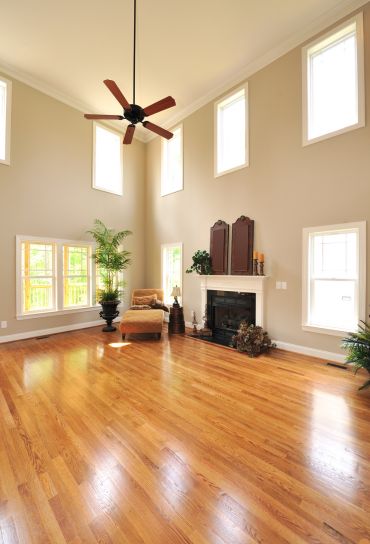 Expansive living room with hardwood flooring and ceiling fans, representing a flooring service based in Springfield, IL.