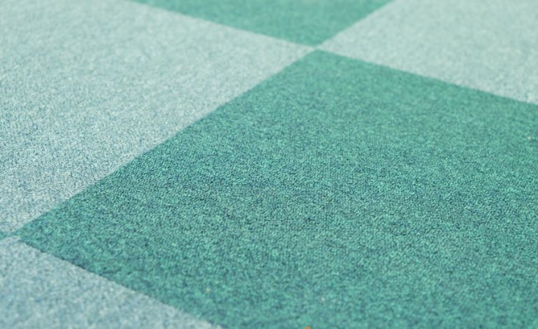 Carpet tile with a green and blue square design, highlighting flooring services offered in Springfield, IL.