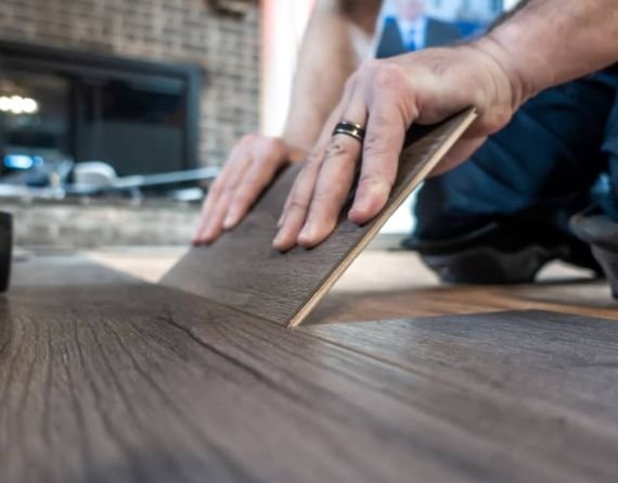 A man installing wooden flooring, representing a flooring service based in Springfield, IL.